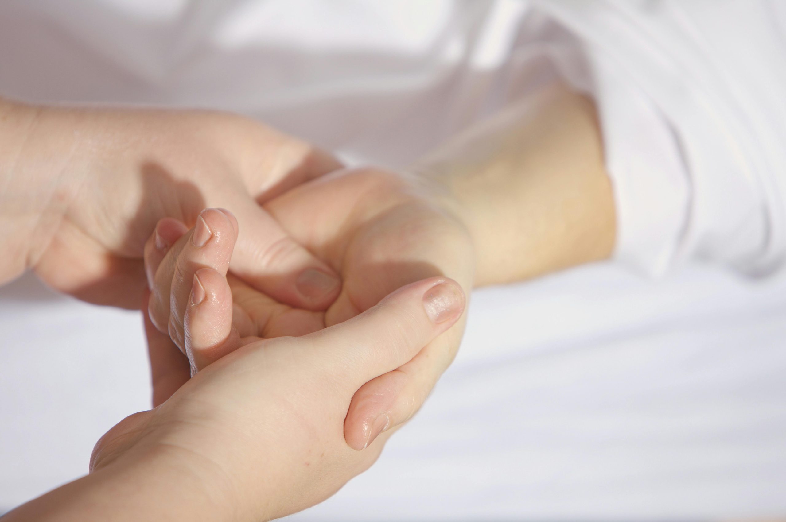 A professional massage therapist gently performing a hand massage, symbolizing healing, care, and wellness at our certified massage center in Islamabad.